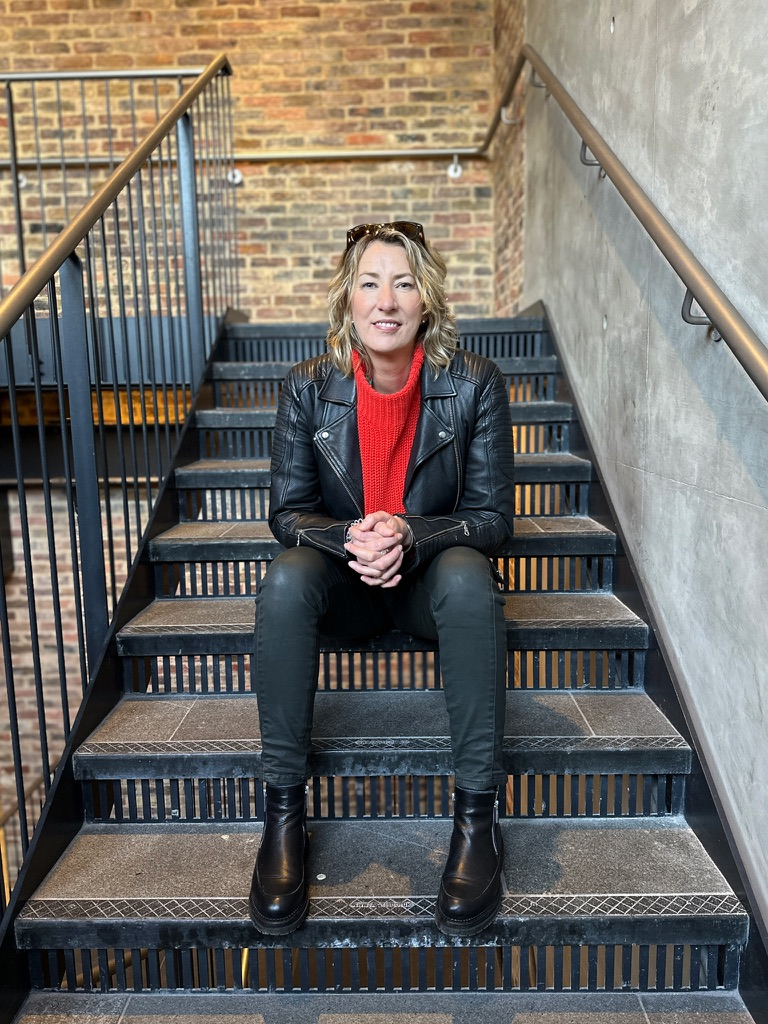 Woman sitting on steps wearing a red jumper