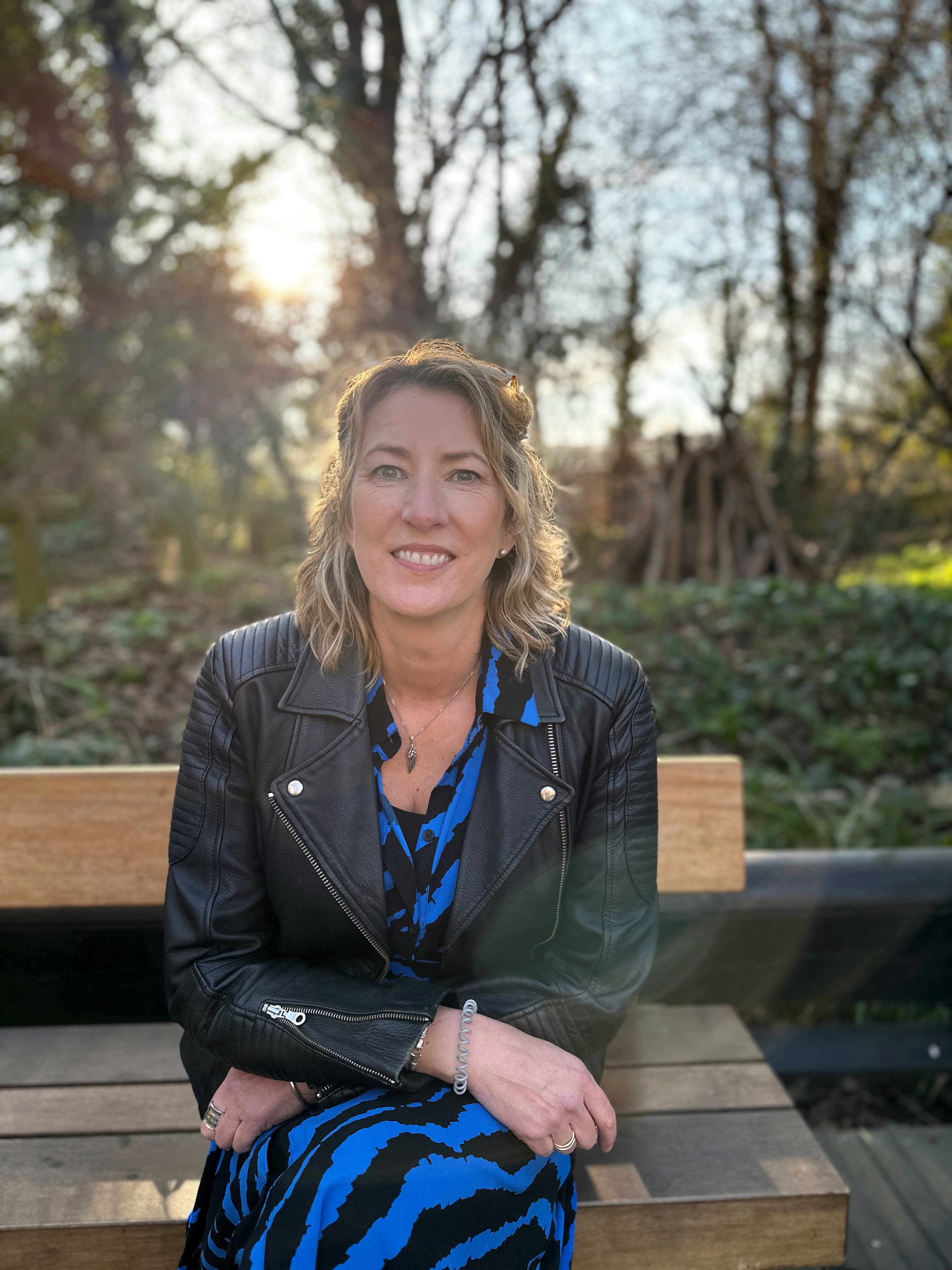 Woman sitting on a bench in a leather jacket